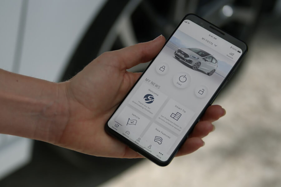 Ford Fiesta in Weiss. Detailansicht eines Smartphones mit Ford Pass App.